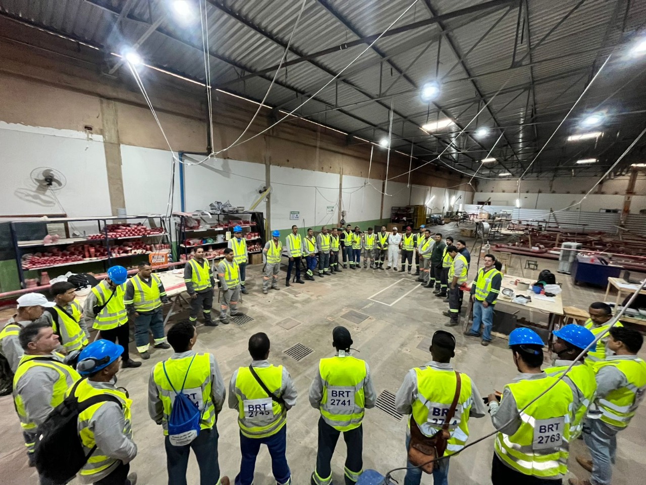 Equipe da Brito Engenharia reunida em obra, de uniforme e equipamento de proteção